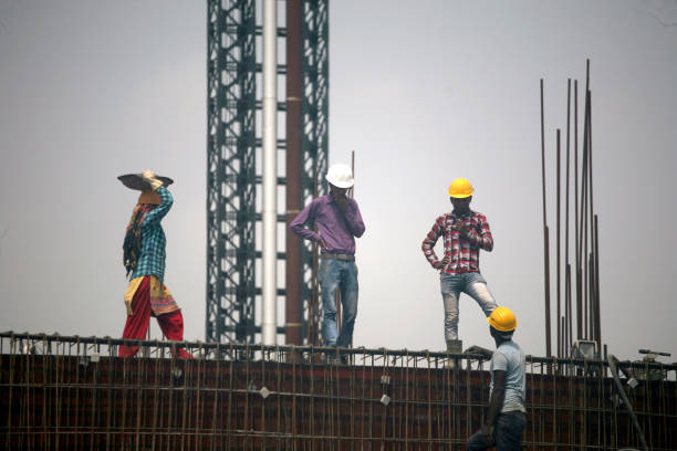 Indian Labourers Busy In Their Work At A Construction Site In New Delhi.